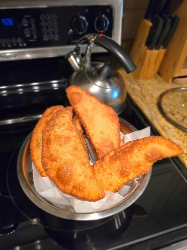 Golden fried Dominican pastelitos in a basket